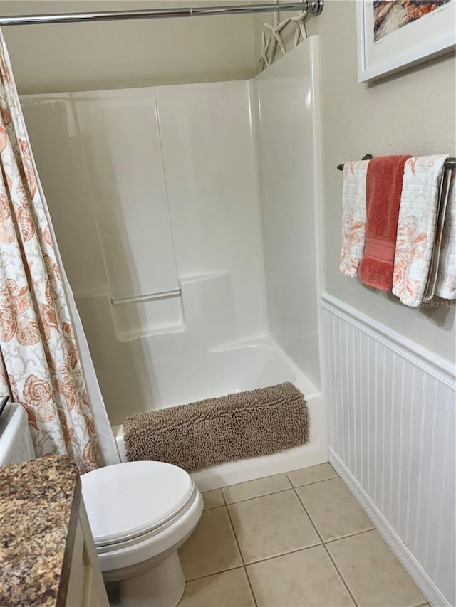 full bathroom featuring tile patterned flooring, shower / bath combo with shower curtain, toilet, and vanity