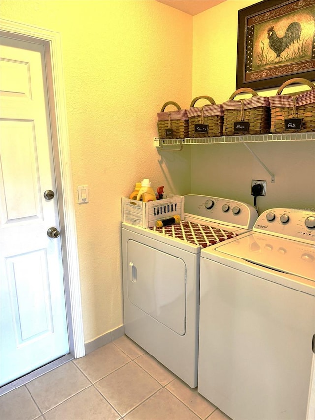 laundry room with light tile patterned floors and washer and clothes dryer