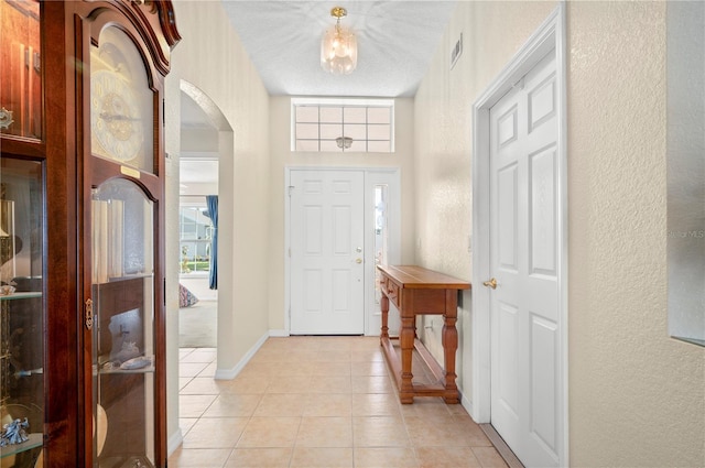 foyer with a textured ceiling and light tile patterned floors