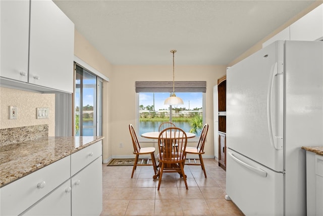 dining room featuring a water view and light tile patterned floors