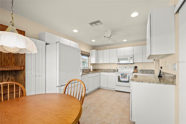 kitchen with light stone counters, ceiling fan, white cabinetry, sink, and white appliances