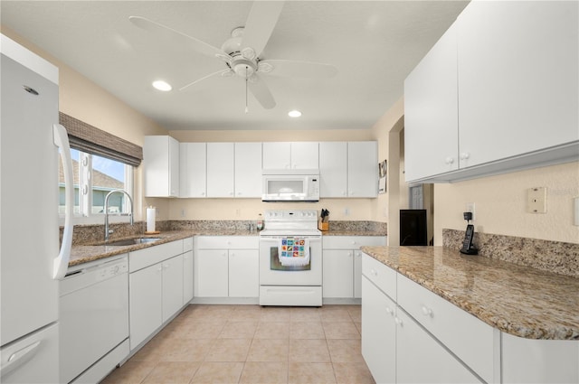 kitchen featuring sink, light tile patterned floors, white cabinetry, light stone counters, and white appliances