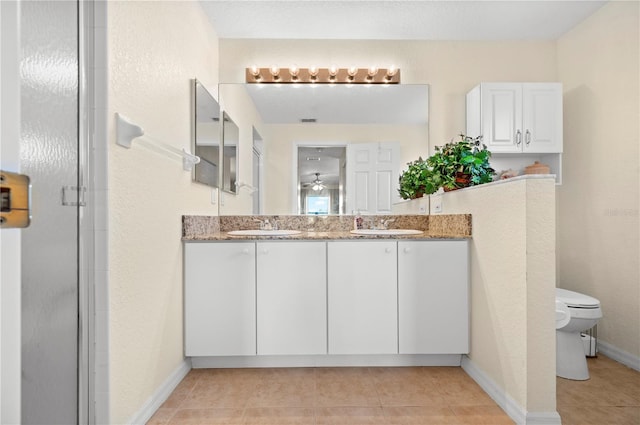 bathroom with ceiling fan, a shower with door, toilet, vanity, and tile patterned floors