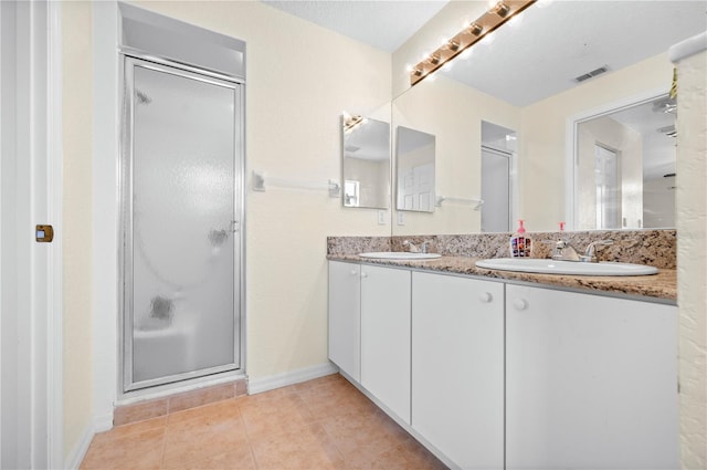 bathroom with vanity, a shower with shower door, and tile patterned flooring