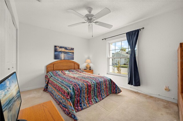 bedroom with light carpet, a closet, and ceiling fan