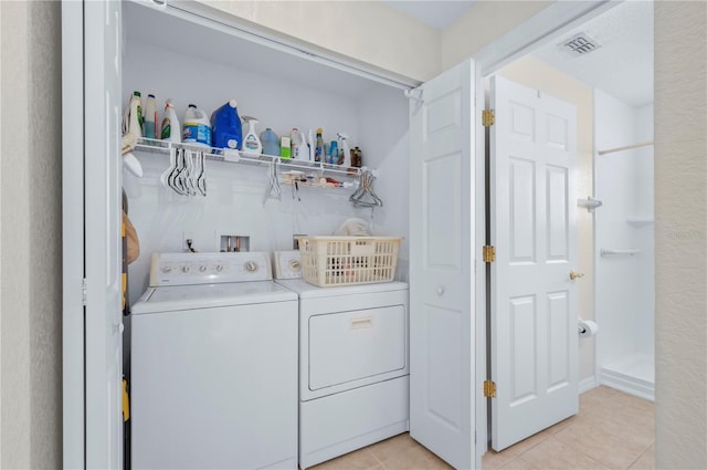 washroom with light tile patterned floors and washing machine and clothes dryer