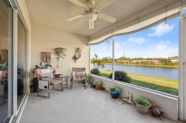 sunroom with a water view and ceiling fan