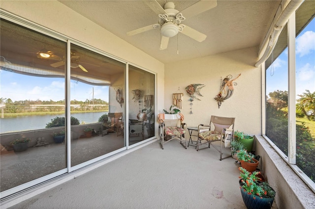 sunroom with a water view and ceiling fan