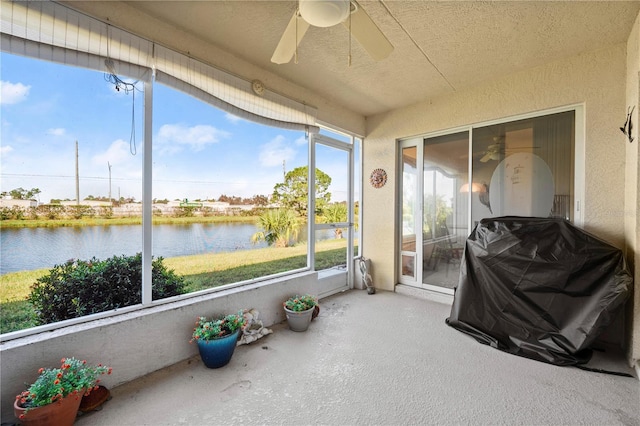 sunroom featuring a water view, ceiling fan, and a healthy amount of sunlight