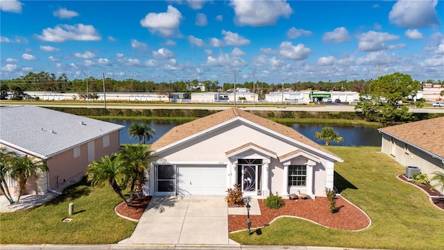 view of front of home featuring a front lawn, a garage, and a water view