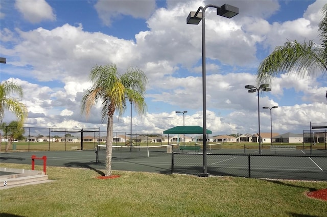 view of tennis court featuring a yard