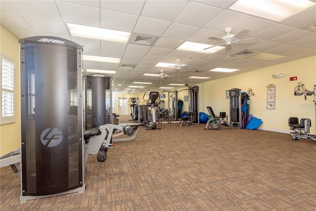 workout area featuring ceiling fan and a drop ceiling