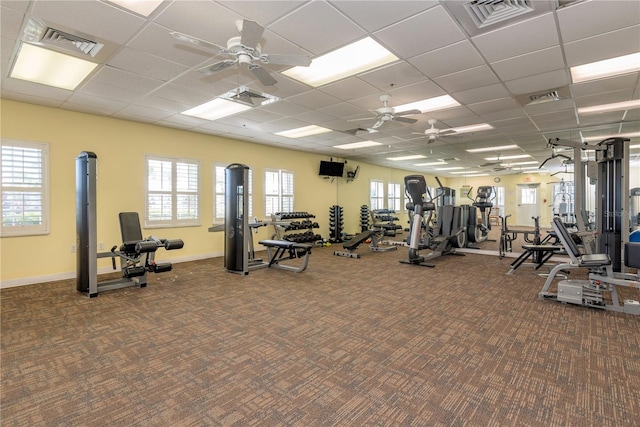 workout area with a drop ceiling and a wealth of natural light