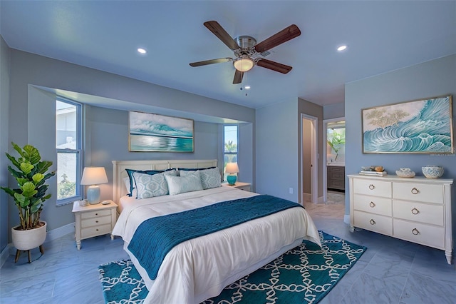 bedroom featuring ceiling fan, connected bathroom, and multiple windows