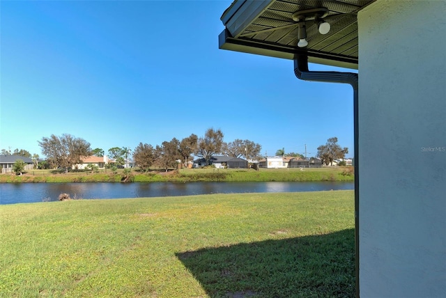 view of yard featuring a residential view, a water view, and ceiling fan