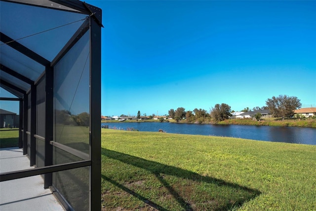 view of yard featuring a water view and glass enclosure