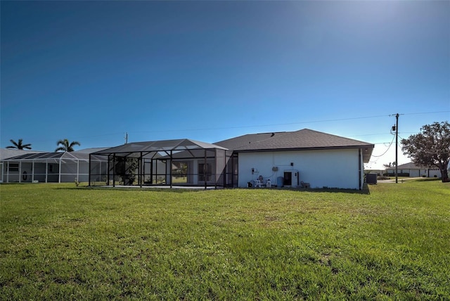 rear view of property with stucco siding and a yard