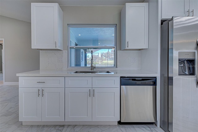 kitchen with white cabinets, appliances with stainless steel finishes, sink, and tasteful backsplash