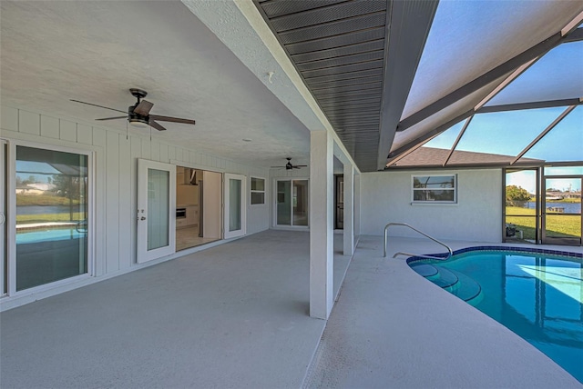 view of swimming pool with ceiling fan, a lanai, and a patio area