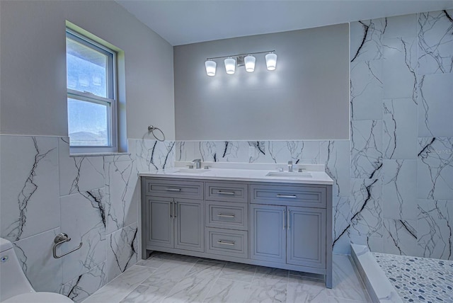 full bathroom featuring a sink, tile walls, walk in shower, and marble finish floor