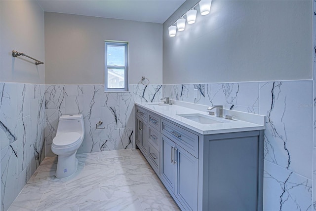 bathroom with tile walls, vanity, and toilet