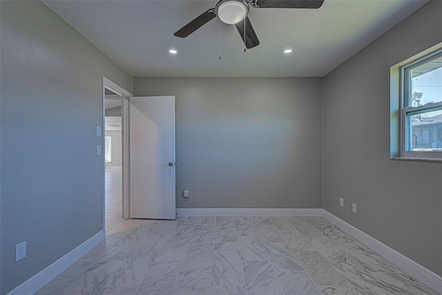 empty room featuring recessed lighting, a ceiling fan, marble finish floor, and baseboards