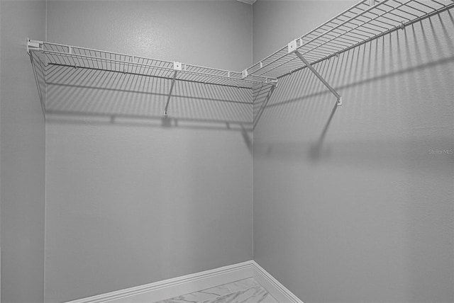 spacious closet featuring marble finish floor