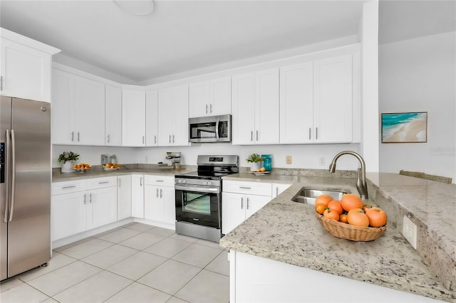 kitchen with light stone countertops, sink, stainless steel appliances, and white cabinets