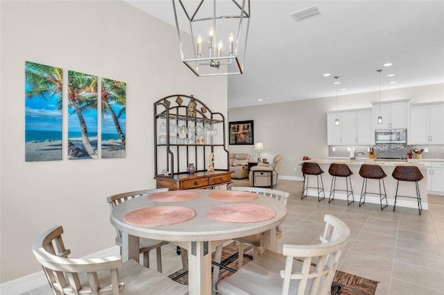 dining area with light tile patterned flooring and an inviting chandelier