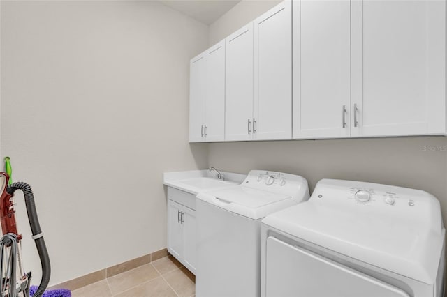 washroom with independent washer and dryer, cabinets, sink, and light tile patterned floors