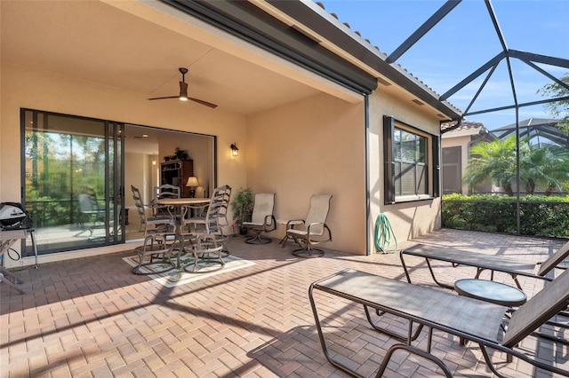 view of patio / terrace with ceiling fan and a lanai