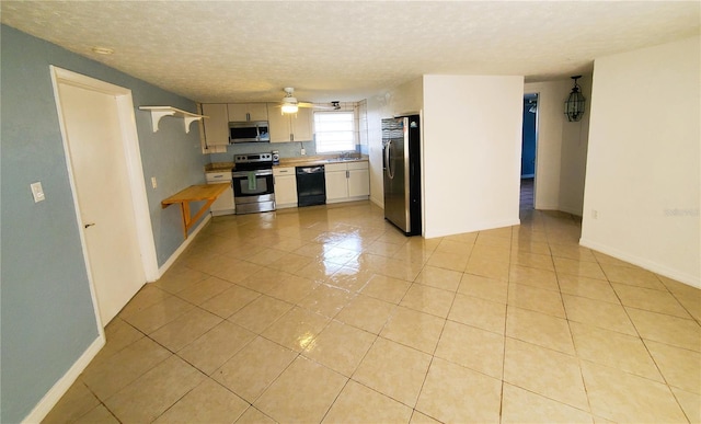 kitchen featuring ceiling fan, light tile patterned flooring, stainless steel appliances, and a textured ceiling