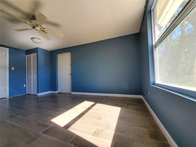 empty room with hardwood / wood-style floors, a wealth of natural light, and ceiling fan