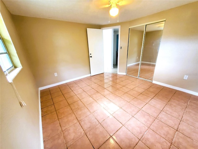 unfurnished bedroom with ceiling fan, light tile patterned floors, and a closet