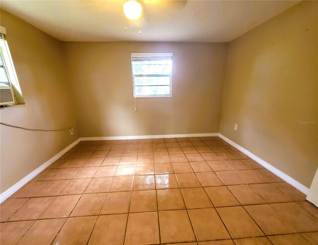 tiled spare room featuring ceiling fan