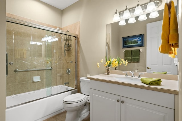 full bathroom featuring vanity, toilet, tile patterned flooring, and bath / shower combo with glass door