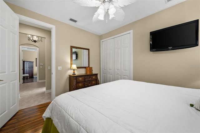 bedroom featuring a closet, dark hardwood / wood-style floors, and ceiling fan