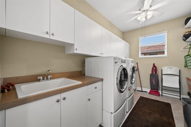 washroom featuring sink, washing machine and clothes dryer, ceiling fan, cabinets, and light tile patterned floors