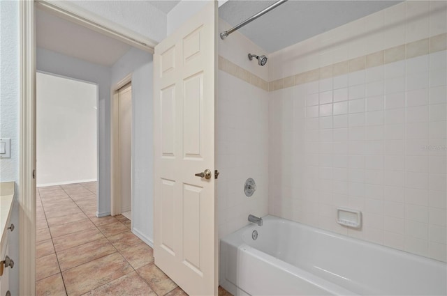 bathroom with tiled shower / bath combo, vanity, and tile patterned flooring