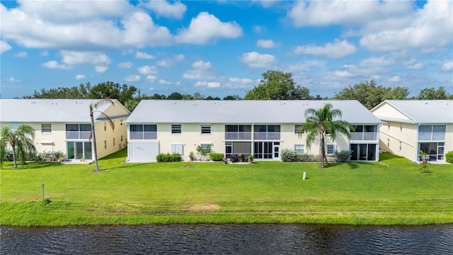 back of house featuring a water view and a yard