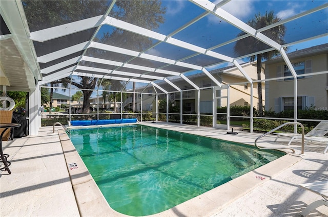 view of swimming pool featuring glass enclosure and a patio