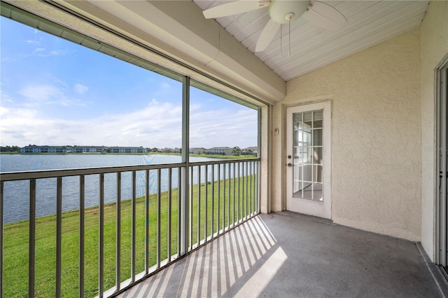 unfurnished sunroom with vaulted ceiling, ceiling fan, and a water view