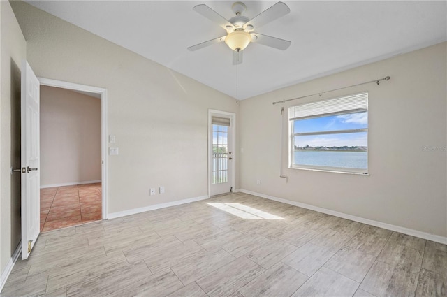 unfurnished room with a water view, vaulted ceiling, and ceiling fan