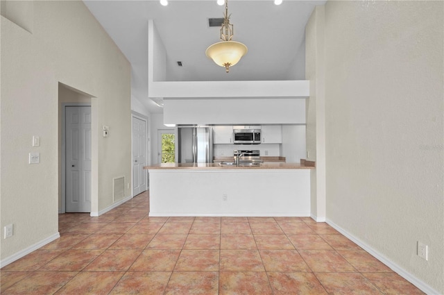 kitchen featuring decorative light fixtures, sink, appliances with stainless steel finishes, and kitchen peninsula