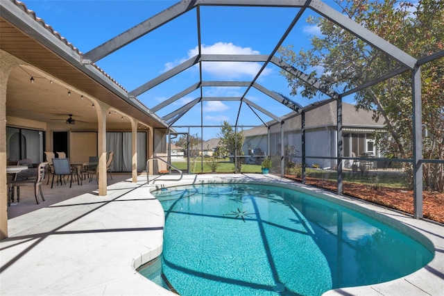 view of swimming pool with glass enclosure, ceiling fan, and a patio