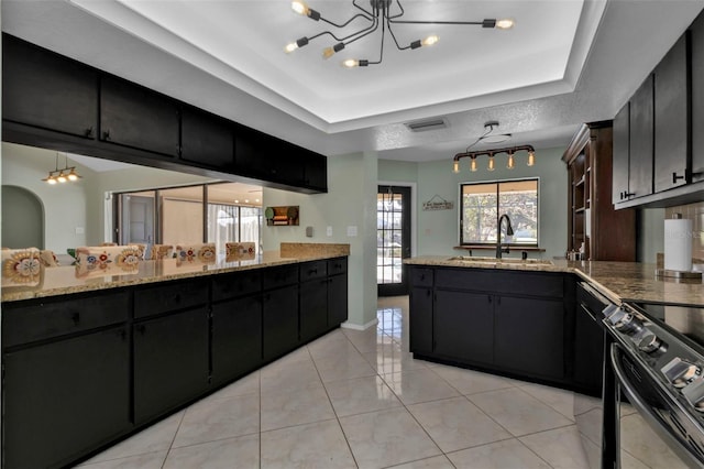 kitchen with pendant lighting, electric range, sink, and an inviting chandelier