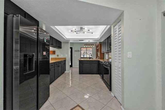 kitchen with stainless steel refrigerator with ice dispenser, black range oven, sink, light tile patterned floors, and a notable chandelier