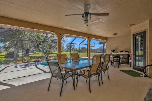 sunroom / solarium with ceiling fan and a swimming pool