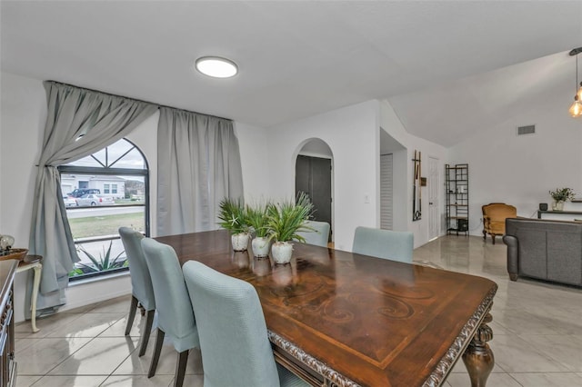 tiled dining room featuring lofted ceiling