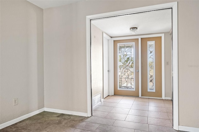 tiled foyer featuring a textured ceiling